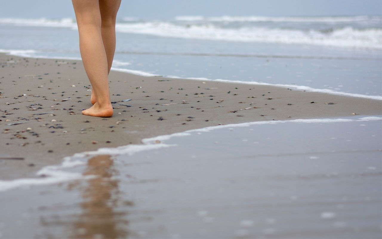 Marcher dans le sable, les pieds caressés par les vagues
