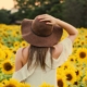 Femme au chapeau dans un champs de tournesols