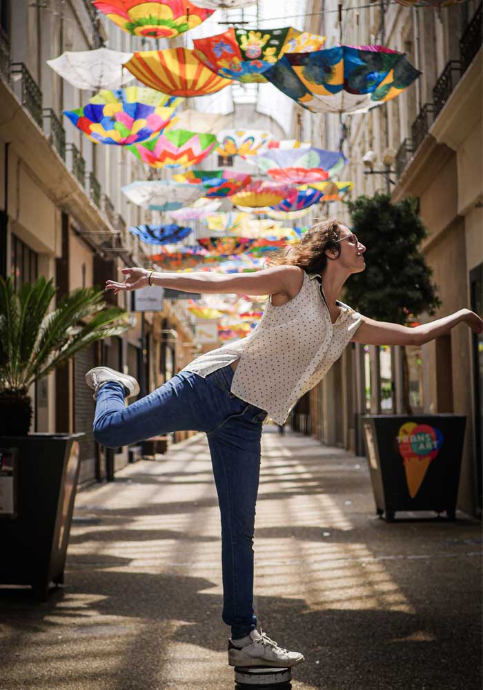 Lila Berard dans un passage parisien décoré de parapluies tombants